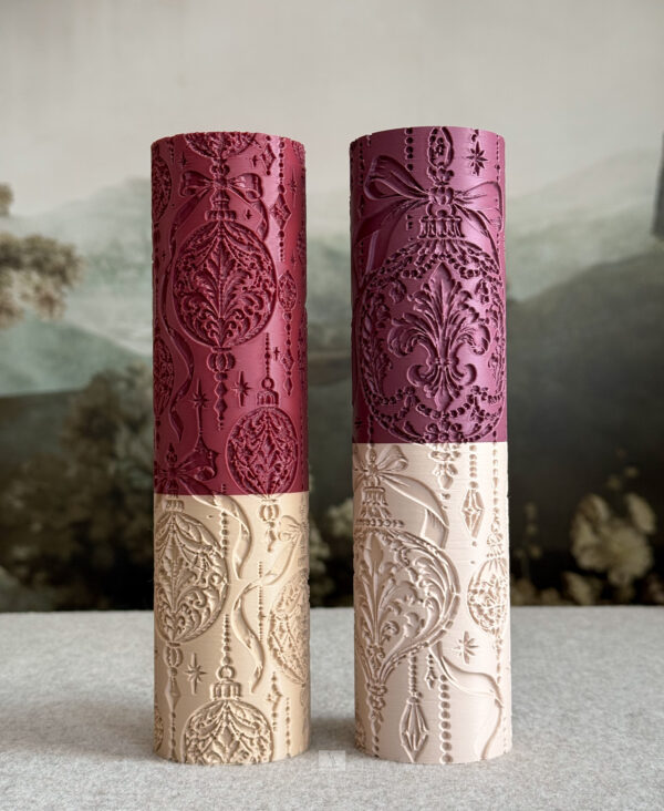 Two Christmas ornament textured rolling pins in burgundy and ivory, featuring intricate baubles, bows, stars, and hanging beads.