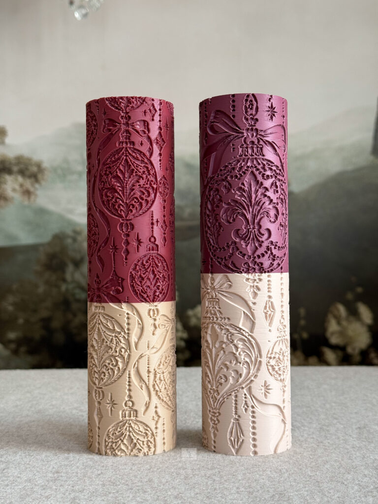 Two Christmas ornament textured rolling pins in burgundy and ivory, featuring intricate baubles, bows, stars, and hanging beads.